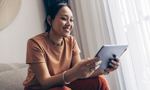lachende aziatishe vrouw op tablet